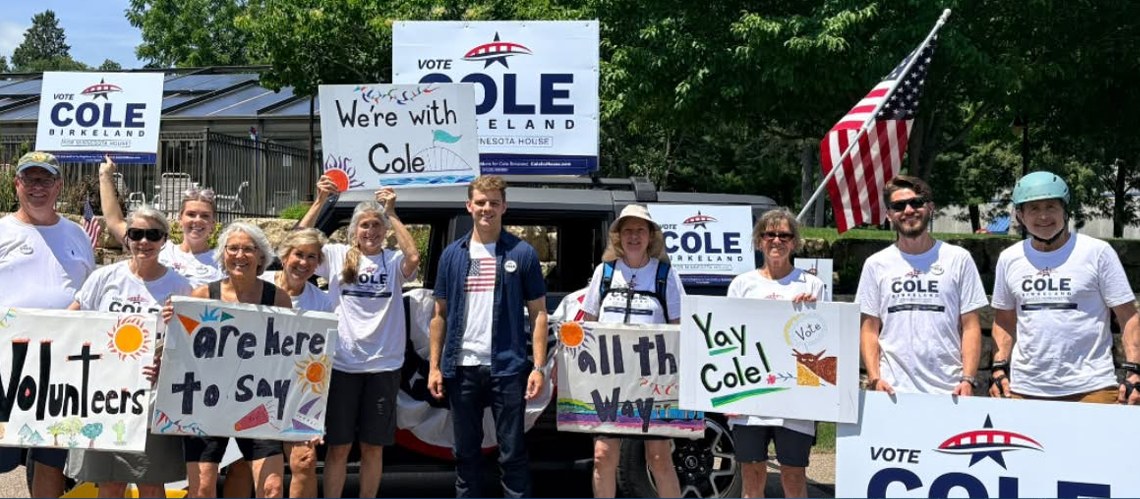 Cole Birkeland with volunteers holding campaign signs